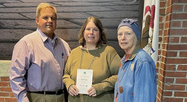 Woman receiving certificate with her guests