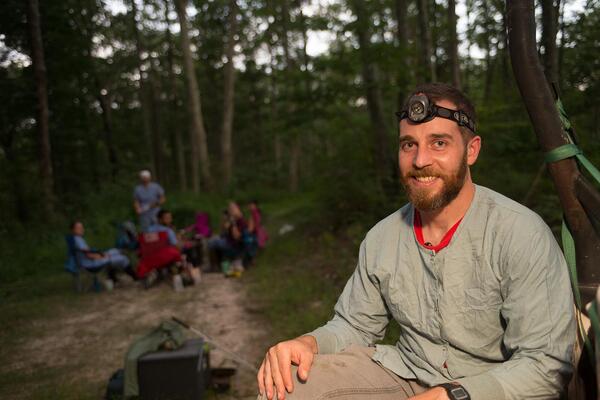 man watching for bats in the woods