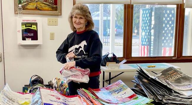 Woman at table with handbags she helped craft