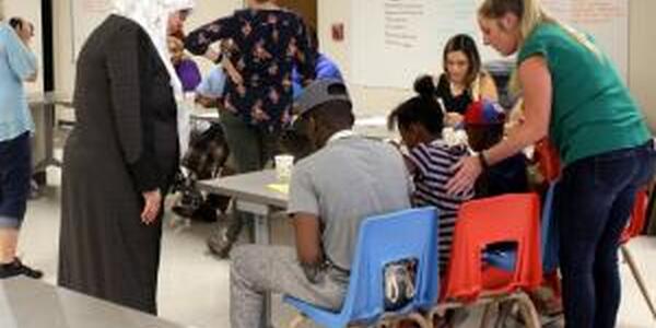 families working with staff members and learning in a classroom