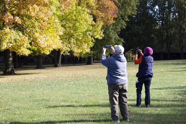 2 Extension master gardeners taking photos of trees