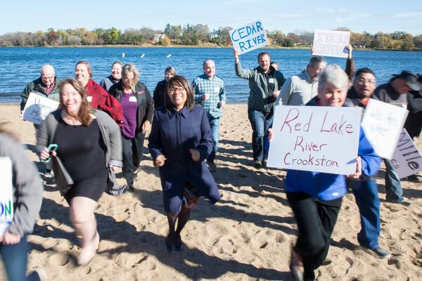 diverse group of people on the sandy shore of a lake