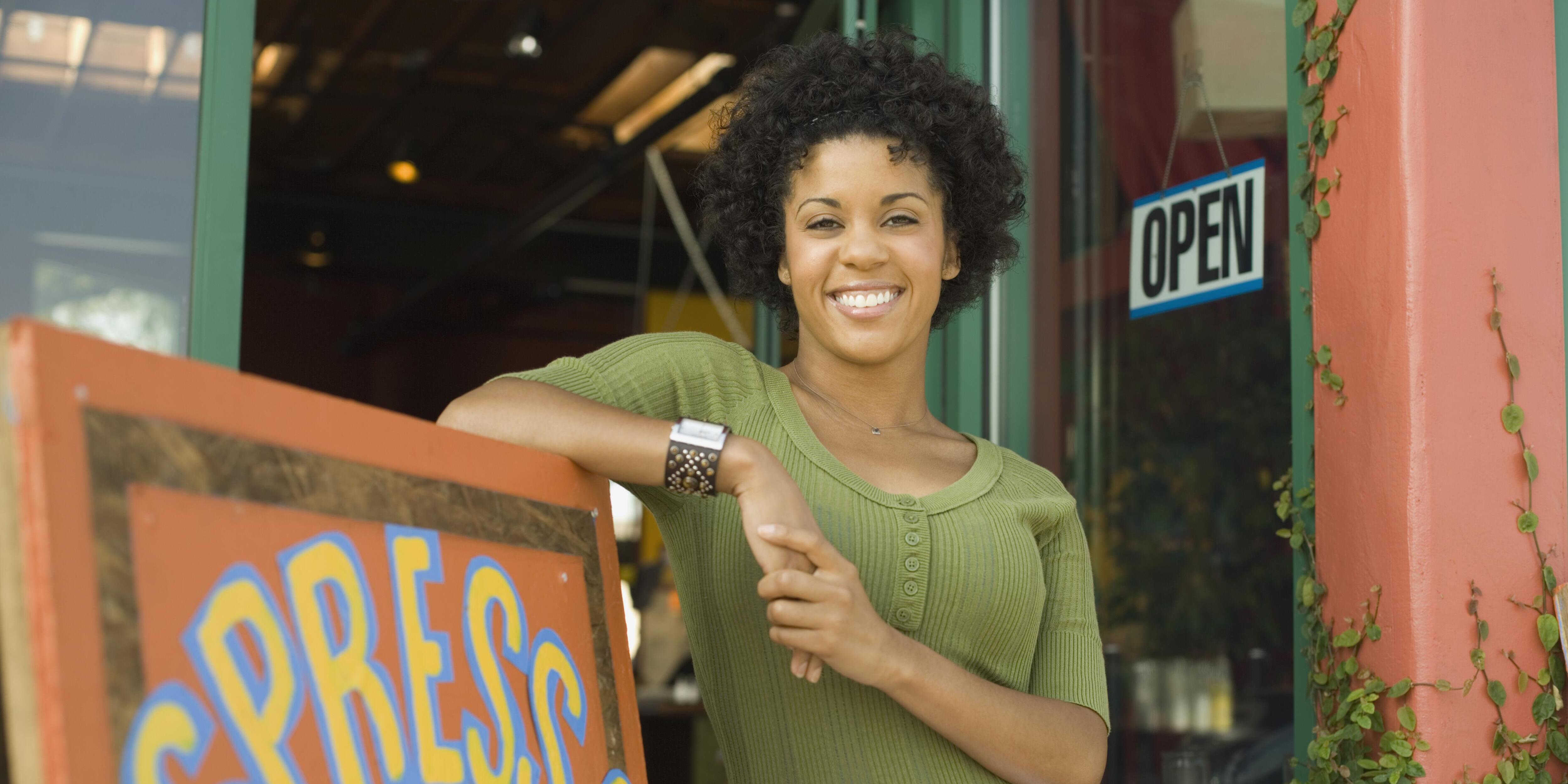 Woman standing in front of her coffee shop