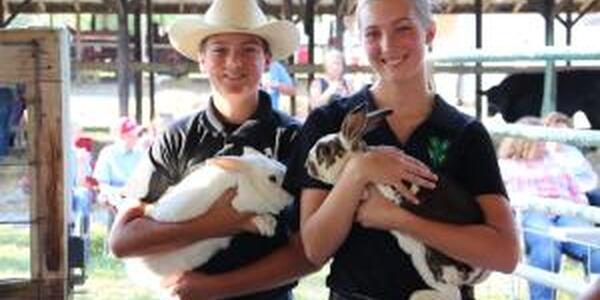 2 youth holding rabbits