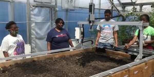 4 youth with robot planting seeds