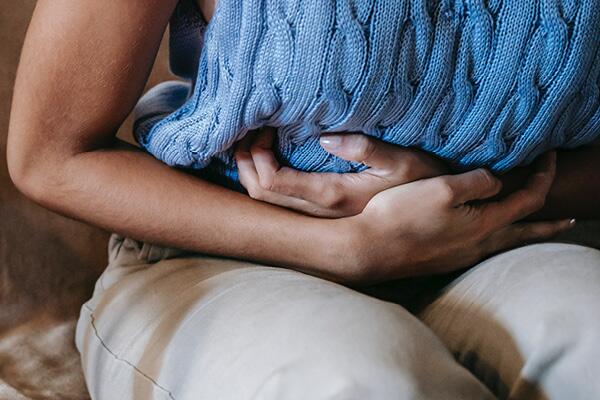 woman hunched with arms over stomach