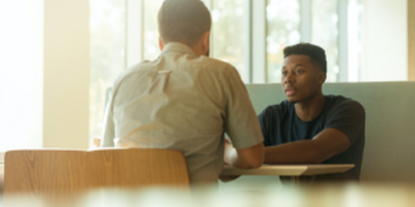 Two men talking at a table