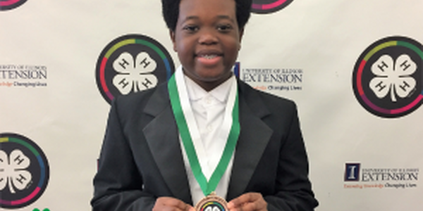 boy holding a 4-H medallion