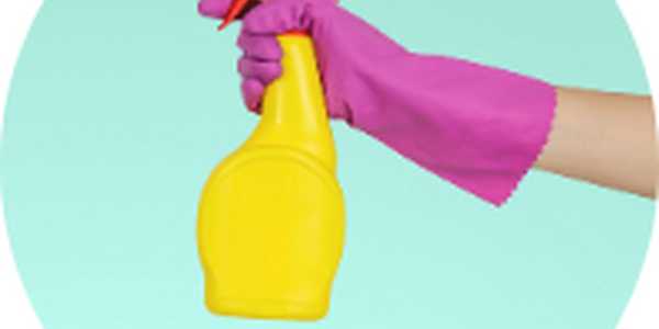 gloved hand holding plastic spray bottle